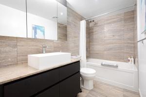 a bathroom with a sink and a toilet and a tub at Luxury 3-BR Retreat in Downtown Toronto in Toronto