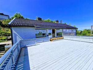 a house with a large wooden deck in front of it at Comfortable Apartment Sleeps 3 Near Kristiansand City Center in Kristiansand