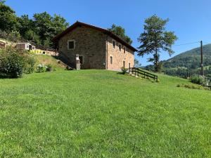 un bâtiment sur une colline avec un champ herbeux dans l'établissement CASA DE LA LASTRA Luena, à San Miguel de Luena