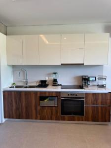 a kitchen with white cabinets and a sink at Arama Bay Relaxation, Luxury and Elegance by the Sea in Bucerías +19 photos