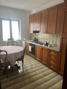 a kitchen with a table and a sink and a stove at Appartamento Luisa 2 in Domaso