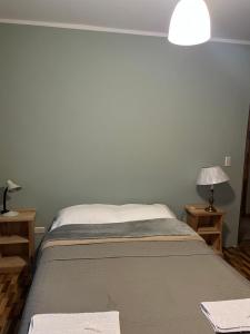 a bedroom with a bed and two tables with lamps at Casa Las Victorias in San Carlos de Bariloche