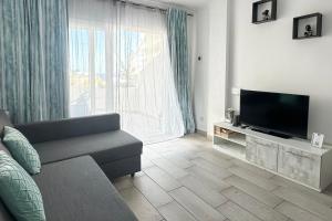 アデへにあるApartment in Ocean Park, Costa Adeje, Tenerifeのソファと薄型テレビのあるリビングルーム
