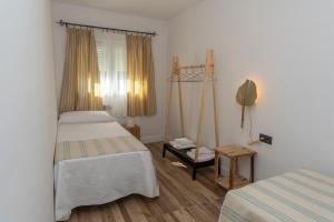 una camera con due letti, una finestra e un tavolo di Cortijillo La Molinera a Jerez del Marquesado