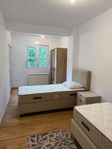 a bedroom with two beds and a window at Family Apartment Durmitor in Žabljak