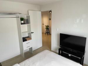 a bedroom with a bed and a flat screen tv at Modern apartment near ValQuirico-Puebla Airport in Huejotzingo