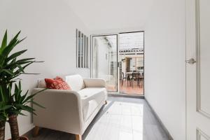 a white living room with a white couch and a window at Hogar con encanto a 10 min del centro de Valencia in Valencia