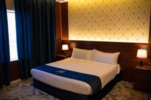 a hotel room with a large bed with two lamps at فندق اريس الماسي in Medina