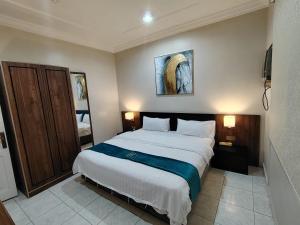 a bedroom with a large white bed with two lamps at مركز السراج للوحدات المخدومة in Jeddah