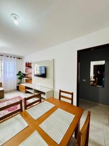 a living room with a dining table and a living room with at Apartamento coração de arraial in Arraial do Cabo