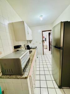a kitchen with a sink and a refrigerator at Apartamento coração de arraial in Arraial do Cabo