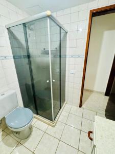 a bathroom with a toilet and a glass shower at Apartamento coração de arraial in Arraial do Cabo +11 photos