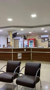a waiting room with two chairs in front of a counter at Casablanca Palace Hotel Frutal MG in Frutal