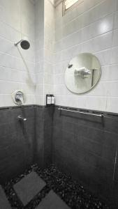 uma casa de banho com um chuveiro e um espelho. em Dago Family Stay em Bandung mais 10 fotografias