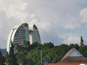 um grande edifício branco com árvores na frente em Dago Family Stay em Bandung