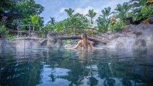 a woman sitting in a swimming pool at a resort at Hotel Los Lagos Spa & Resort in Fortuna