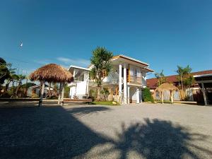 a house with a palm tree and a bench at Laid back Pool Villa Chiang Rai in Chiang Rai