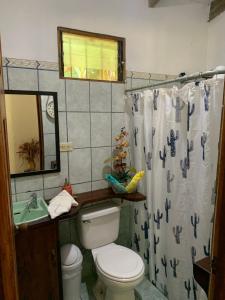 Un baño con inodoro y cortina de ducha en Oceana Breeze Perfect Getaway steps from the beach, en Sámara