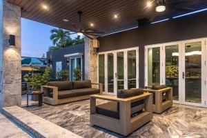 eine Terrasse mit Sofas und Tischen auf einem Haus in der Unterkunft El Carlton - KingRoom Pool - Resort Vibe Near Beach in San Juan