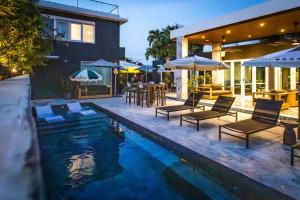 ein Swimmingpool mit Stühlen und Sonnenschirmen neben einem Haus in der Unterkunft El Carlton - KingRoom Pool - Resort Vibe Near Beach in San Juan