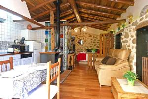 a kitchen and living room with a couch and a table at Casa Rural El Cuco in Robledillo