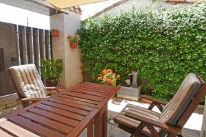 - une table en bois et 2 chaises sur la terrasse dans l'établissement Casa Rural El Cuco, à Robledillo