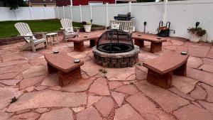 a patio with a fire pit and picnic tables and chairs at Stunning Historic Home Lots of Space In Town in Kanab +94 photos