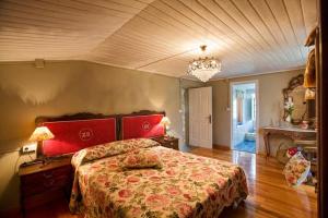 a bedroom with a large bed and a chandelier at La Calleja in Arzúa