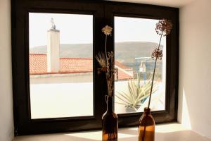 two vases sitting on a window sill with flowers in them at Vivenda Montanha Apartment in Alcaria