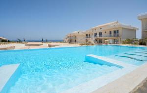 a large swimming pool in front of a building at Stunning Apartment In Marzamemi in Marzamemi