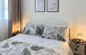 a bedroom with a bed with pillows and two lamps at Stunning Apartment In Marzamemi in Marzamemi