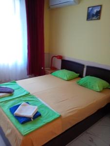 Un dormitorio con dos camas con almohadas verdes. en Apartments Vicente, en Golden Sands