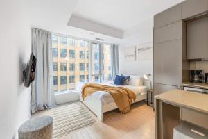 a bedroom with a bed and a large window at Urban Oasis Central Studio Condo Perfect Getaway in Toronto