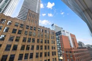 a tall building in a city with tall buildings at Urban Oasis Central Studio Condo Perfect Getaway in Toronto