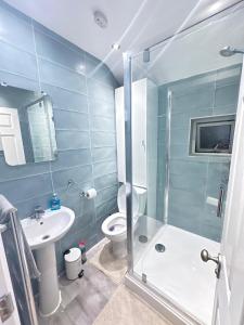 a bathroom with a shower and a toilet and a sink at Stylish & Cosy 3 BR in Gravesend in Northfleet