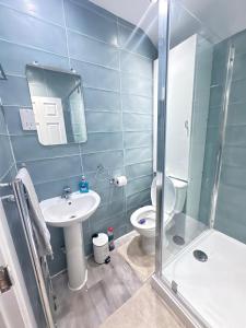 a bathroom with a toilet and a sink and a shower at Stylish & Cosy 3 BR in Gravesend in Northfleet