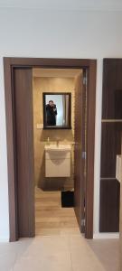 baño con lavabo y TV en la pared en Zafiro Apartments 4 pax, en Buenos Aires