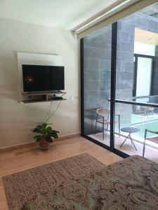 a bedroom with a flat screen tv on a wall at Enjoy yourself in Heaven! in Playa del Carmen
