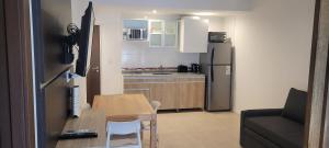 Una pequeña cocina con una mesa y un refrigerador. en Zafiro Apartments 4 pax, en Buenos Aires