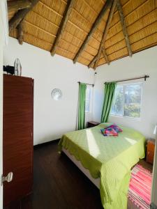 a bedroom with a green bed in a room with a window at Las Totoras PDD in Punta Del Diablo +25 photos