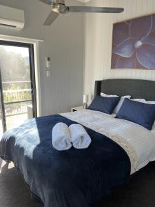 une chambre avec un lit avec deux serviettes dessus dans l'établissement Back Creek Estate Cottage, à Severnlea