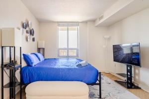 a bedroom with a blue bed and a flat screen tv at DTSS LuxePad 2BED 2BATH Washington DC Balcony Views, Gym, Pool, Free Parking in Silver Spring