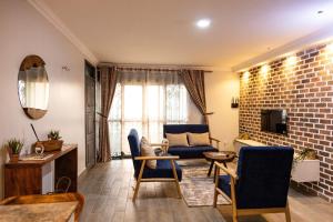 a living room with a blue couch and a brick wall at The apartments-Bwebajja in Bwebajja