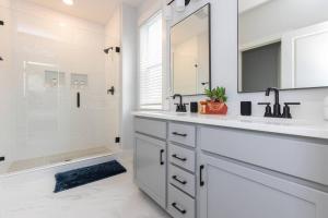ein weißes Badezimmer mit Waschbecken und Dusche in der Unterkunft Birdsong Bungalow - Hot Tub, Game Room, Fire Pit in Charlotte + 59 Fotos