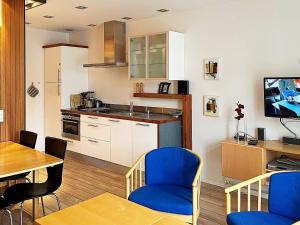 a kitchen with a table and blue chairs in a room at Central Oasis in Lokken - By Traum Ferienwohnungen in Løkken