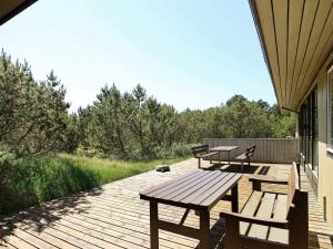 une terrasse en bois avec des bancs et des tables sur une maison dans l'établissement Luxury Retreat in Blavand - By Traum Ferienwohnungen, à Blåvand