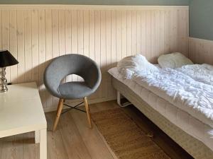 a bedroom with a chair next to a bed at 8 person holiday home in Rødby-By Traum in Rødby