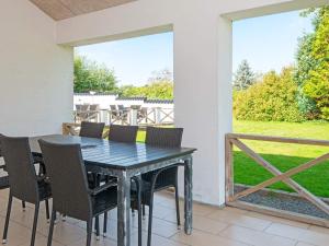 a dining room table and chairs on a patio at 10 person holiday home in Grenaa-By Traum in Grenå