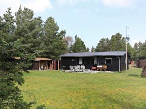 5 person holiday home in Vejers Strand-By Traum في فايرس ستراند: كوخ أسود مع طاولة نزهة في الفناء