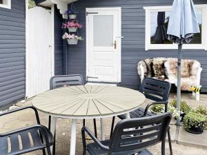 グレーノにある6 person holiday home in Grenaa-By Traumのテーブルと椅子と傘のあるパティオ